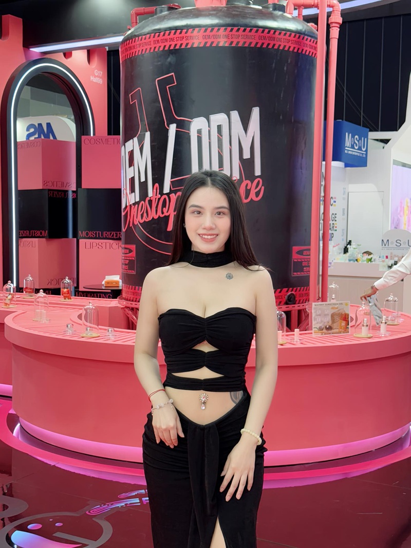 Linh Miu đứng trước quầy bar tone hồng