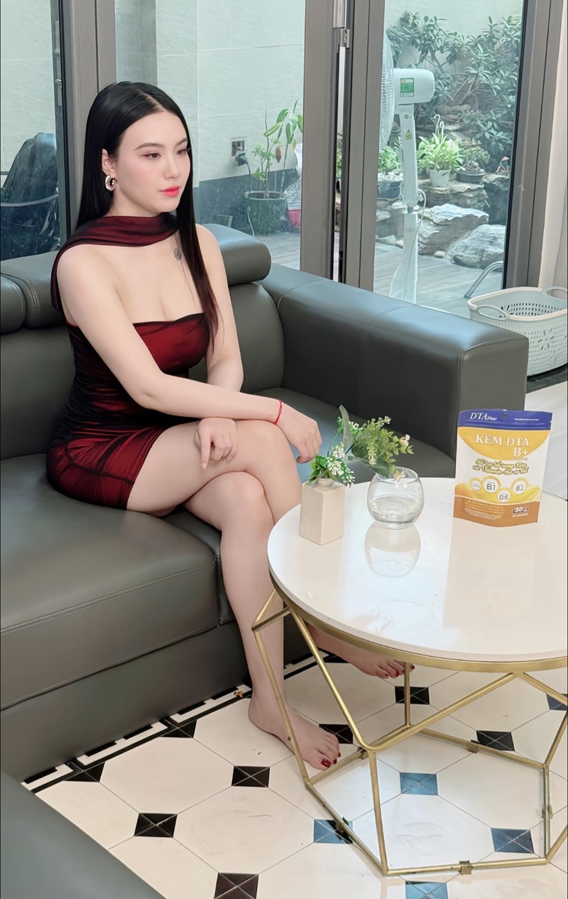 Linh Miu mặc váy đỏ ngồi sofa nhẹ nhàng