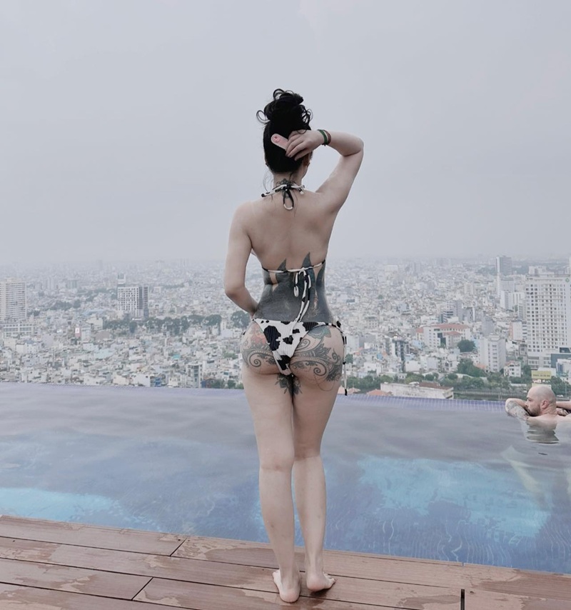 Linh Miu đứng quay lưng giữa hồ bơi view cao