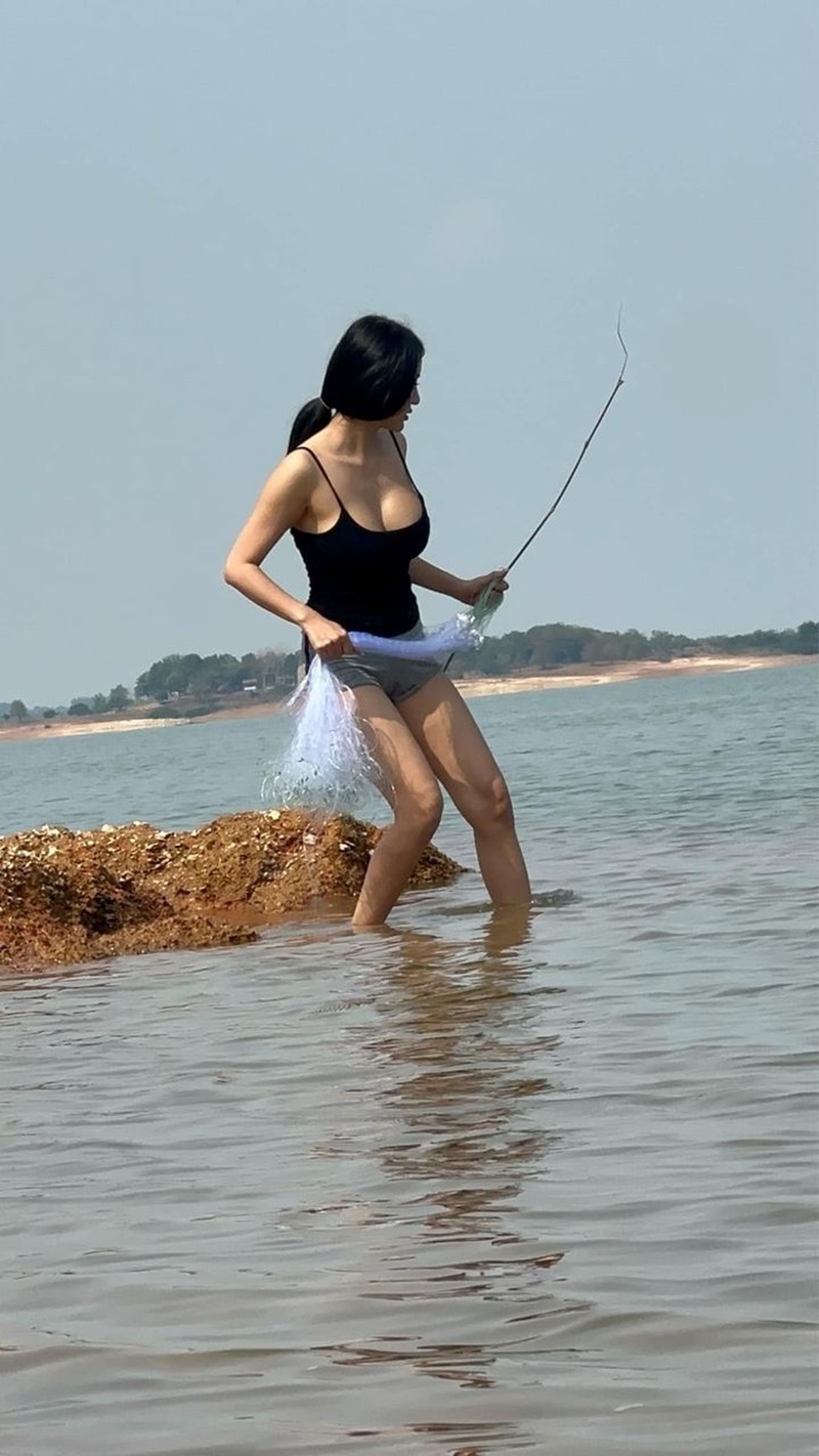 Pong Kyubi mặc bikini đen đứng tắm biển bên bờ cát
