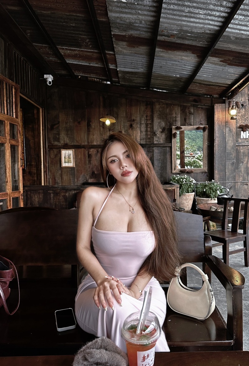 Suniebae mặc áo bra trắng ren ngồi trên ghế sofa trong quán cà phê
