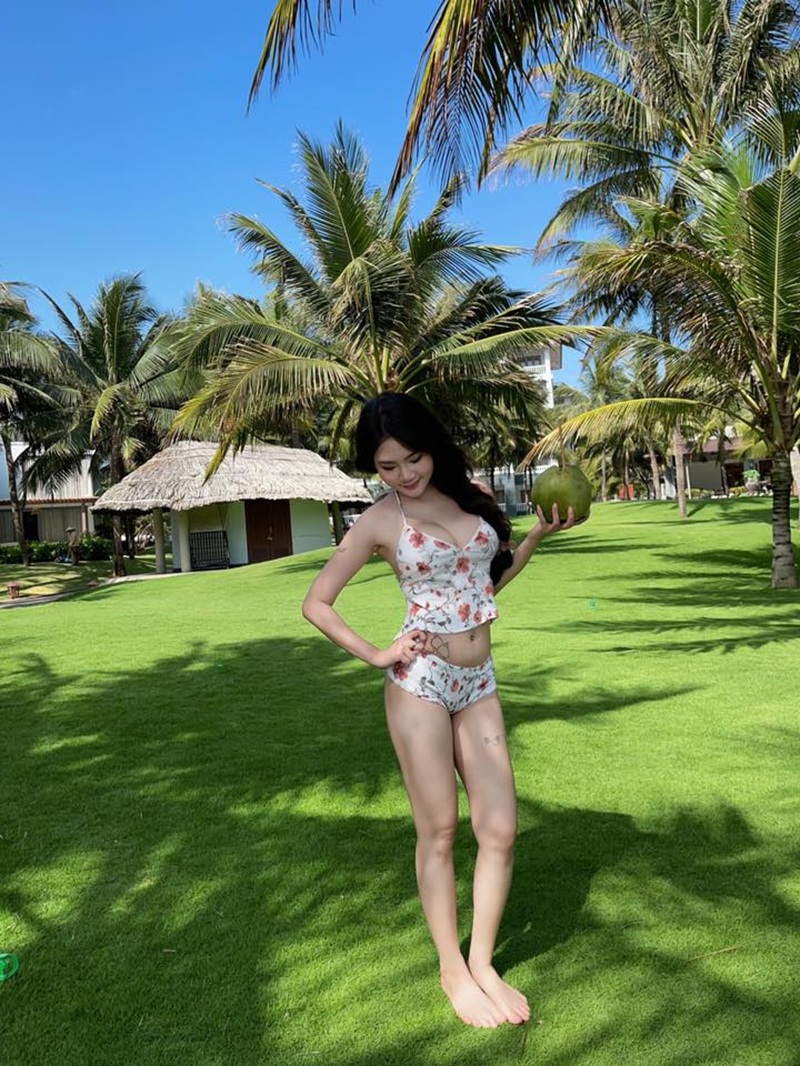 Thanh Nhàn mặc bikini hoa đứng trên bãi cỏ rộng