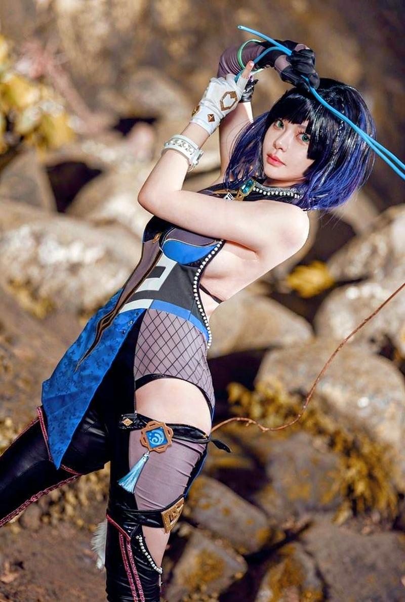 Cosplay Yelan pose đứng dựa tường ánh sáng tím