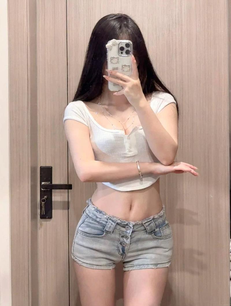 Nữ model crop top đen hở eo bên cửa sổ